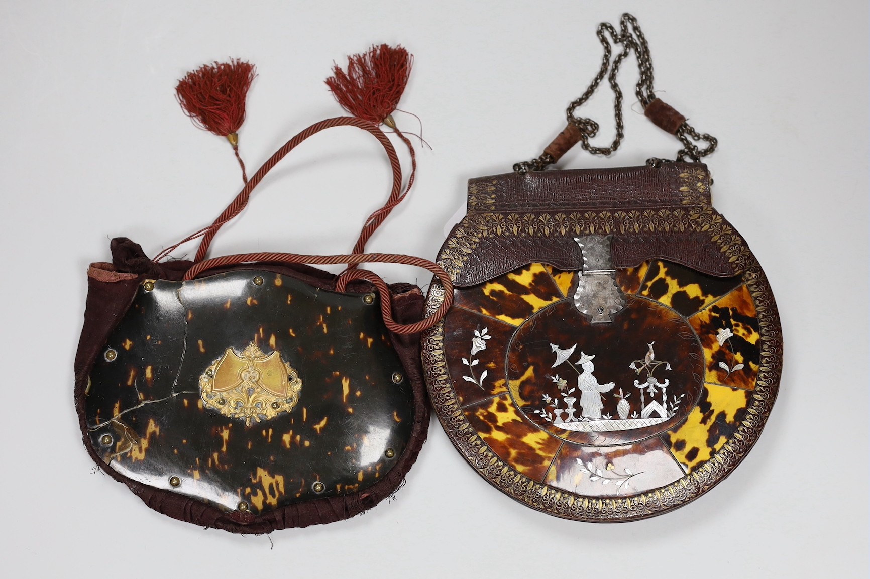 A 19th century circular tooled leather, tortoiseshell and mother of pearl mounted lady’s handbag having a cut steel clasp and chain handle and another similar bag(2)